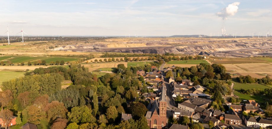 Luftbildaufnahme Dorf, im Hintergrund Tagebau