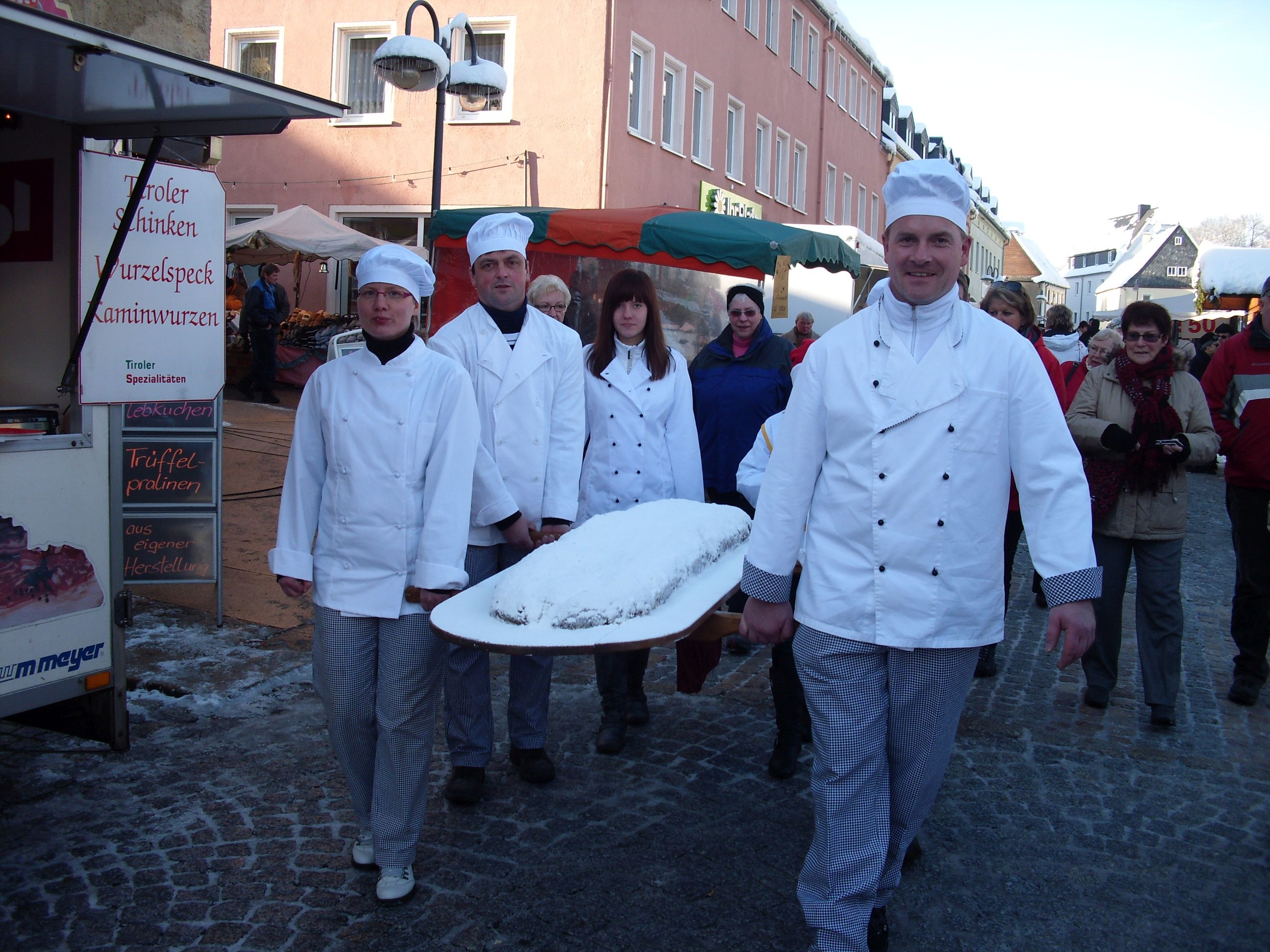 Bäcker tragen einen sehr großen Christstollen