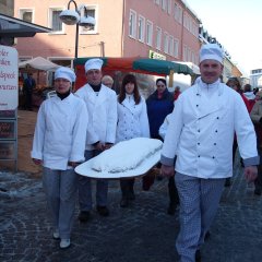 Bäcker tragen einen sehr großen Christstollen